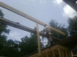 Carpenter setting a ridge beam over a new addition frame — Ice Dam Removal by Roofing Brothers in Lapaz