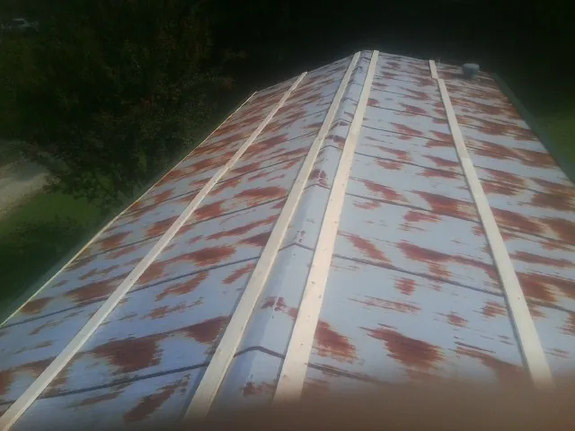 Rusted metal roof panels with new wood purlins before replacement — Storm Damage Roof Repair in Lapaz by Roofing Brothers