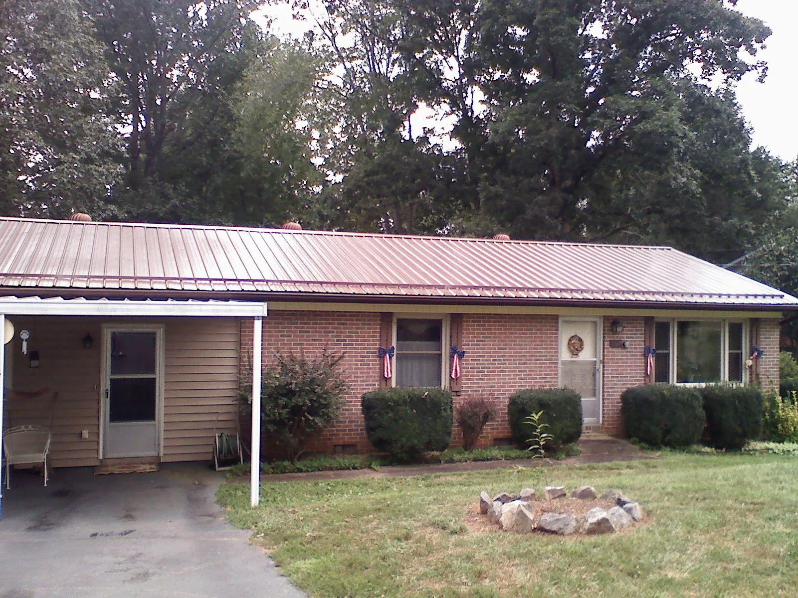 Bronze metal roof and carport on a brick ranch home — Roof Repair work by our crew in Lapaz